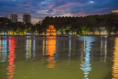Gece vakti Hanoi Kızıl Köprüsü. Hoan Kiem Gölü üzerindeki ahşap kırmızı boyalı köprü kıyıyı ve Ngoc Son Tapınağı 'nın bulunduğu Jade Adası' nı birbirine bağlar.