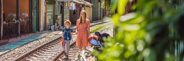 BANNER, LONG FORMAT Anya és fia utazók sétálnak a vasúti utak, amelyek átmennek lakóövezetben Hanoi városban. Hanoi Train Street egy híres turisztikai célpont. Vietnam újra megnyitja után — Stock Fotó