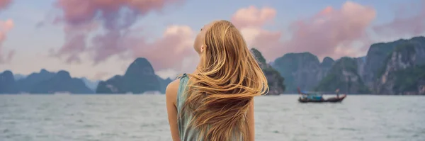 BANNER, LONG FORMAT Attractive woman in a dress is traveling by boat in Halong Bay. Vietnam. Travel to Asia, happiness emotion, summer holiday concept. Picturesque sea landscape. Ha Long Bay, Vietnam