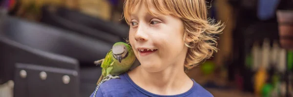 Kind spielt mit seinem grünen Papagei BANNER, LONG FORMAT — Stockfoto