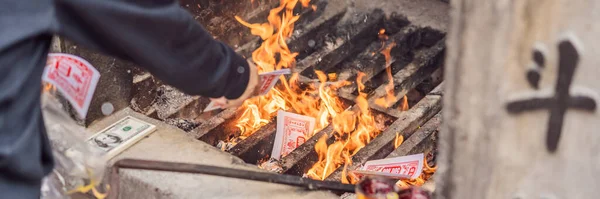 BANNER, LONG FORMAT Burning the silver and gold fake money paper for Chinese dead people ancestors. Joss paper money burning metal bucket dead in Chinese new year