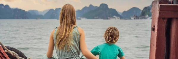 BANNER, LONG FORMAT Mom and son travelers is traveling by boat in Halong Bay. Vietnam. Travel to Asia, happiness emotion, summer holiday concept. Traveling with children concept. After COVID 19