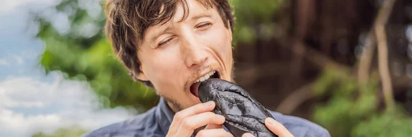 Hombre comiendo cerdo vietnamita Banh Mi Sandwich en una baguette negra BANNER, FORMATO LARGO — Foto de Stock