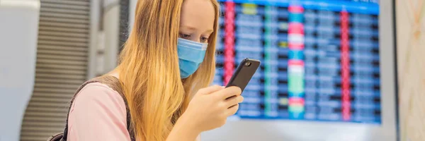 Женщина-путешественница в медицинской маске для защиты коронавируса в аэропорту Баннер, длинный Формат — стоковое фото