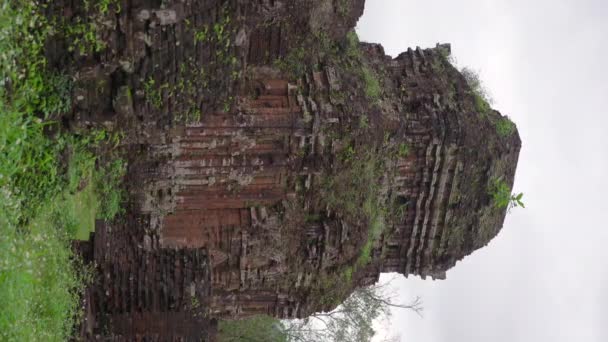 Vidéo verticale. Coup de feu à la main de ruines dans le sanctuaire My Son, vestiges d'une ancienne civilisation Cham au Vietnam. Destination touristique dans la ville de Danang. Voyage au Vietnam concept — Video