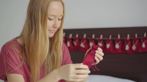 Een jonge vrouw bereidt een adventskalender voor haar kind — Stockvideo