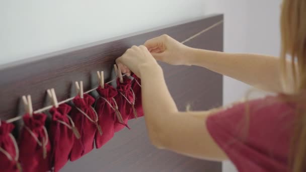 A young woman prepares an advent calendar for her child — Stock Video