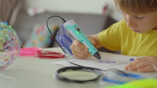 Gros plan d'un petit garçon qui utilise un stylo 3d — Video