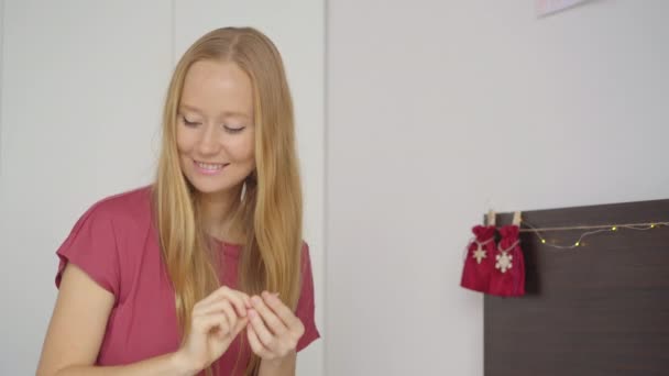 A young woman prepares an advent calendar for her child — Stock Video