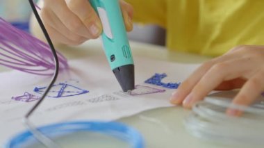 3D kalem kullanan küçük bir çocuğun yakın plan çekimi.