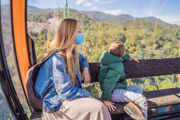 Mom and son are travelers wearing medical masks due to coronavirus COVID 19. Cable car to famous tourist attraction - European city at the top of the Ba Na Hills, Vietnam — Stock Photo, Image