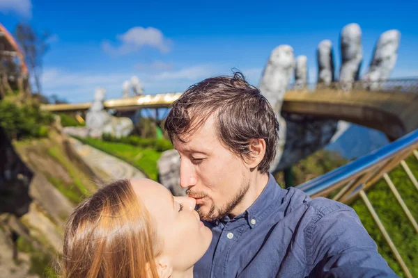 Joven pareja de turistas en la famosa atracción turística - Puente de oro en la cima de las colinas de Ba Na, Vietnam —  Fotos de Stock