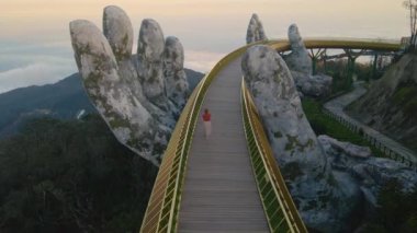 Danang şehrindeki Altın Köprü 'de yürüyen genç bir kadının yavaş çekim görüntüsü. Vietnam 'ın merkezinde bir turizm merkezi. Vietnam 'a seyahat