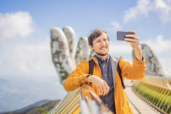 Fiatal férfi turista a híres turisztikai attrakció - Arany híd tetején a Ba Na Hills, Vietnam — Stock Fotó