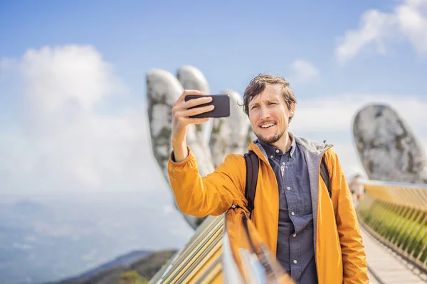 Fiatal férfi turista a híres turisztikai attrakció - Arany híd tetején a Ba Na Hills, Vietnam — Stock Fotó