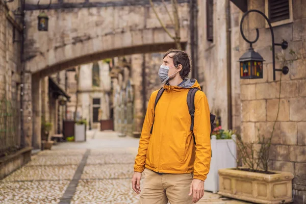 Junger Mann mit medizinischer Maske während des COVID-19 Coronavirus Touristen spaziert nach dem Ende des COVID-19 Coronavirus die Straße in einer europäischen Stadt entlang. Quarantäne — Stockfoto