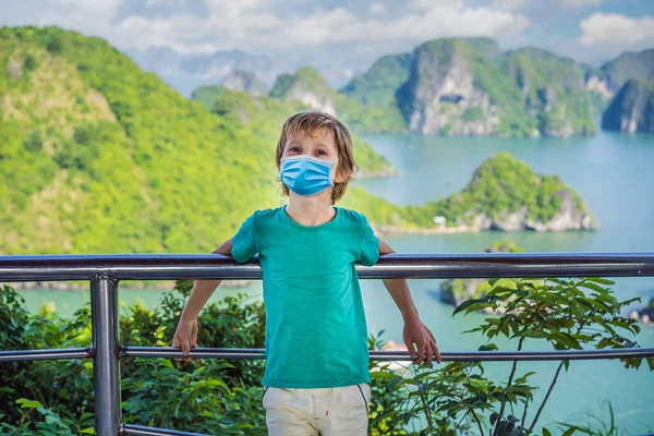 Halong Bay 의 COVID-19 코로나 바이러스 (coronavirus) 에서 의료용 마스크를 착용 한 소년. 베트남. 아시아 여행, 행복 한 감정, 여름휴가같은 개념. 피콜로 레스 크의 바다 풍경입니다. 하 롱만, 베트남 — 스톡 사진