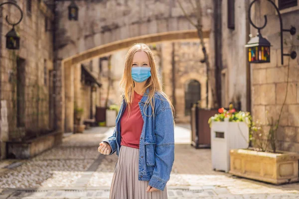 一名头戴口罩的年轻女性在COVID-19科罗纳威斯之旅结束后走在欧洲一个城市的大街上。检疫 — 图库照片