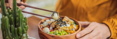 Çiğ Organik Poke Bowl yiyen bir adam. Yanında pilav ve sebzeler var. Üst Görünüm Yukarıdan Yatay BANNER, Uzun Format