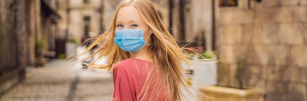 BANNER, LONG FORMAT Une jeune femme portant un masque médical pendant le coronavirus COVID-19 se promène dans une ville européenne après la fin du coronavirus COVID-19. quarantaine — Photo