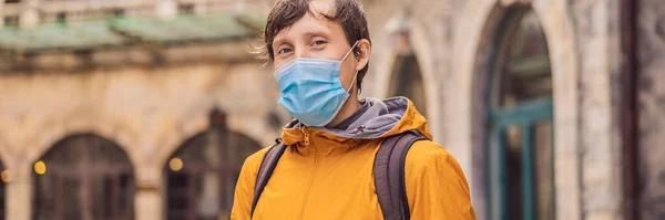 BANNER, LONG FORMAT Jeune homme portant un masque médical pendant le coronavirus COVID-19, un touriste descend la rue dans une ville européenne après la fin du coronavirus COVID-19. quarantaine — Photo