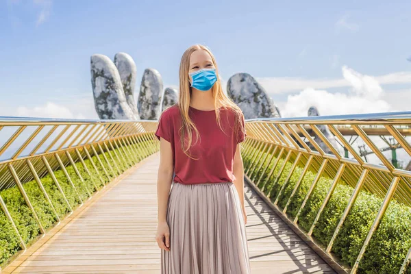 젊은 여성 관광객이 유명 한 관광 명소인 코로나 바이러스 COVID-19 에서 의료용 마스크를 착용하고 있다 - 베트남바나 힐스 정상에 있는 골든 브리지 — 스톡 사진