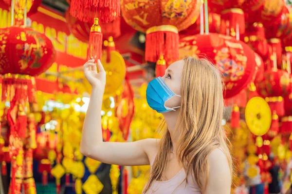 Beautiful Caucasian tourist woman wearing a medical mask during COVID-19 coronavirus wearing a medical mask during COVID-19 coronavirus in Tet holidays. Vietnam Chinese Lunar New Year in springtime
