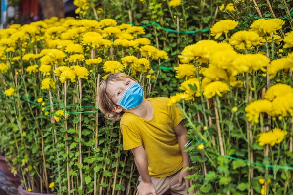 Niño turista caucásico usando una máscara médica durante el coronavirus COVID-19 en las vacaciones del Tet. Vietnam Año Nuevo Lunar chino en primavera — Foto de Stock