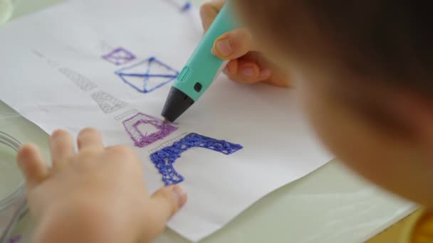 Close Up shot van een kleine jongen die gebruik maakt van een 3d pen — Stockvideo