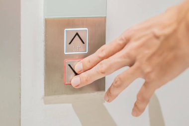 Parmak, asansör düğmesindeki numaraya basar.