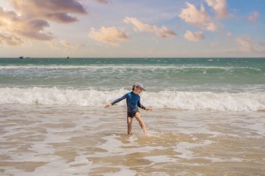 Çocuk deniz sörfünde koşuyor, mutlu bir çocukluk geçiriyor.