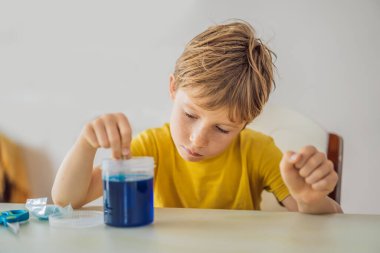 Kimyasal testler. Ev laboratuarı için aletler. Çocuk Explorer. Çocuk kimyasal bir reaksiyon izliyor. Genç kimyager bilimsel deneyler yapıyor. fiziksel deney içeride