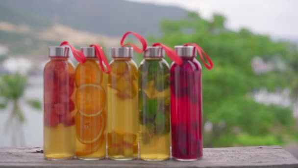 Egy sor színes üveg palack különböző ízű kombucha ital, mint például a görögdinnye, narancs, mangó, menta, sárkánygyümölcs. Egészséges és természetes italok — Stock videók