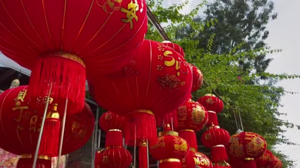 Fotografía en cámara lenta de coloridas linternas chinas rojas y doradas vendidas en un mercado callejero asiático antes de las vacaciones del Tet o el año nuevo lunar en Asia. Concepto TET. Viajar a Asia. Cartas sobre linternas y — Vídeo de stock