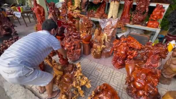 10.02.2021-Nha Trang, Vietnam: TET veya yeni yıl kutlamalarından önce tatil pazarı. Pazarın bu bölümünde oyulmuş ahşap heykeller satılıyor. — Stok video