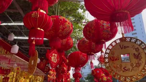 Fotografía en cámara lenta de coloridas linternas chinas rojas y doradas vendidas en un mercado callejero asiático antes de las vacaciones del Tet o el año nuevo lunar en Asia. Concepto TET. Viajar a Asia. Cartas sobre linternas y — Vídeo de stock