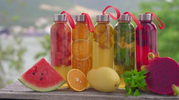 Egy sor színes üveg palack különböző ízű kombucha ital, mint például a görögdinnye, narancs, mangó, menta, sárkánygyümölcs. Egészséges és természetes italok — Stock videók