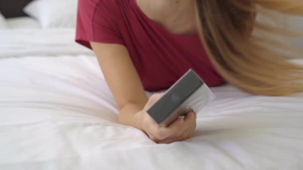 12.01.2021 - Nueva York, Estados Unidos: Mujer joven en su dormitorio abre su nuevo Iphone 12pro — Vídeo de stock