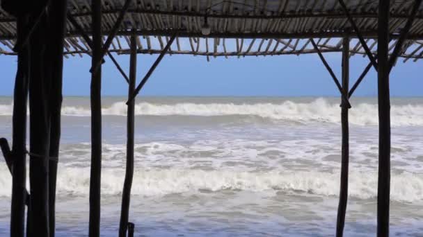 Große stürmische Wellen und Wind. Blick von einem Strandcafé auf stürmischer See an einem sonnigen Tag — Stockvideo