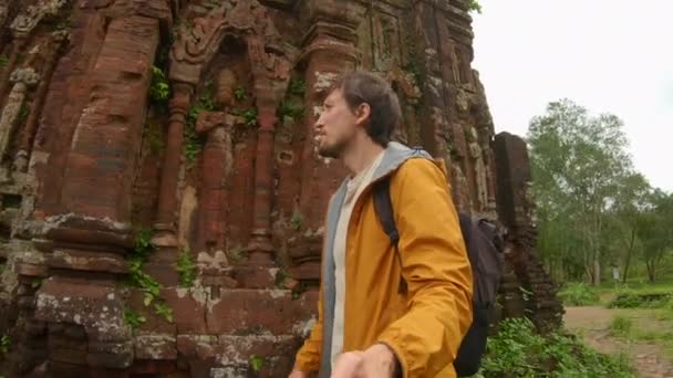 Family visits ruins in the My Son Sanctuary, remains of an ancient Cham civilization in Vietnam. Tourist destination in the city of Danang. Travel to Vietnam concept — Wideo stockowe