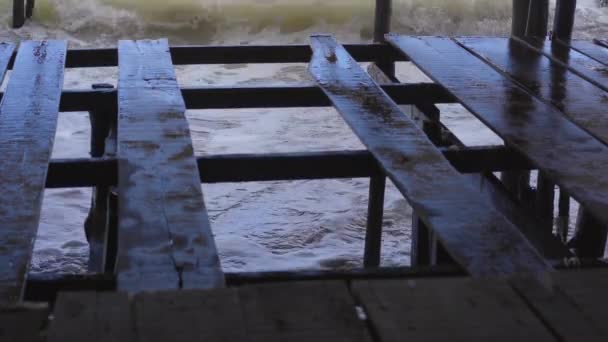 Big stormy waves and wind. View from a beach cafe on a stormy sea on a sunny day. Part of the floor was broken. Waves are coming under the floor — Vídeos de Stock