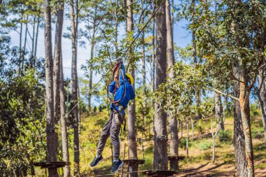 Kasklı mutlu bir çocuk, sağlıklı bir okul çocuğu yaz günü tırmanma parkında eğleniyor.