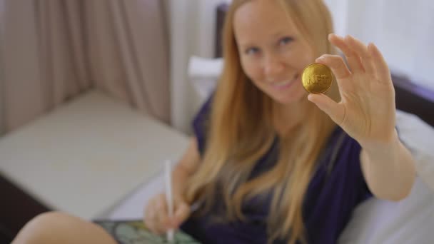 Mulher artista digital, pintor contemporâneo segurar uma moeda NFT em sua mão. Ela está feliz porque está participando de um novo movimento de venda de formas de arte usando a tecnologia blockchain. Moedas NFT são — Vídeo de Stock