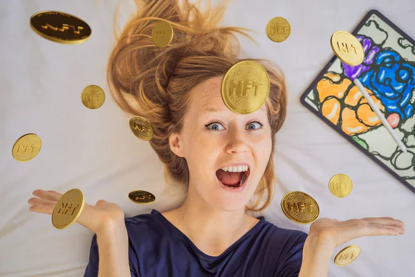 NFT Young woman, a digital artist, creates digital art on a tablet at home and shows a coin with the inscription NTF - non fungible token. Remote work, digital nomad, digital painting, animation — Stock Photo, Image