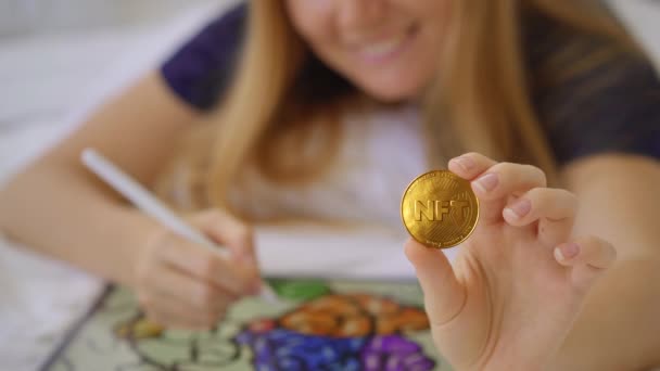 Vrouw digitale kunstenaar schildert op een grafische tablet. Ze droomt ervan om haar kunst te verkopen voor een NFT munt. NFT munten worden gebruikt als bewijs van eigendom voor digitale kunst en worden beschermd door blockchain technologie — Stockvideo