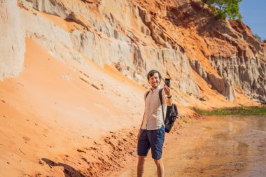 Kızıl kumulların arasındaki Peri deresindeki adam, Muine, Vietnam. Vietnam COVID 19 karantinasından sonra sınır açıyor