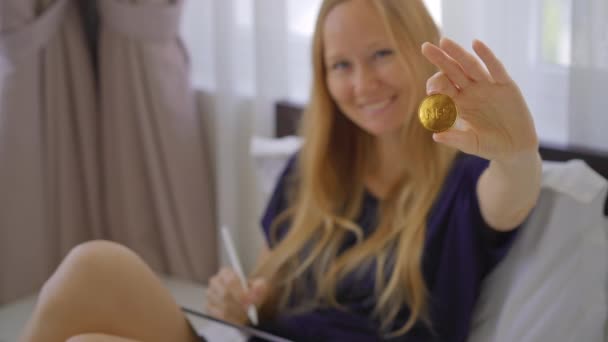 여성 디지털 아티스트, 현대화 가는 NFT 동전을 손에 쥐고 있습니다. 그녀는 블록체인 기술을 사용하여 예술 형식을 판매하는 새로운 운동에 참여하고 있기 때문에 행복해 한다. NFT 동전은 — 비디오