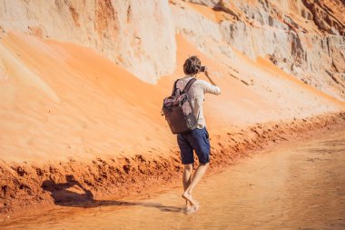 Kızıl kumulların arasındaki Peri deresindeki adam, Muine, Vietnam. Vietnam COVID 19 karantinasından sonra sınır açıyor
