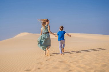 Mother and son in the desert. Traveling with children concept. Tourism reopens after quarantine COVID 19 clipart