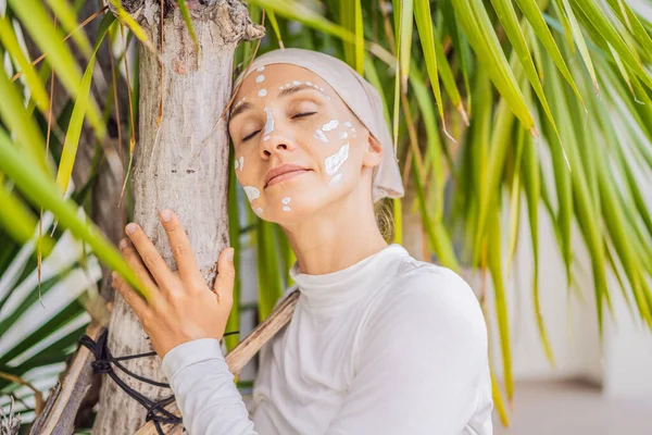 Kundalini yoga woman in white clothes and turban practices yoga kundalini on the background of the sea, mountains and sunset. Fighting face painting of the Indians shows her inner world. Visual